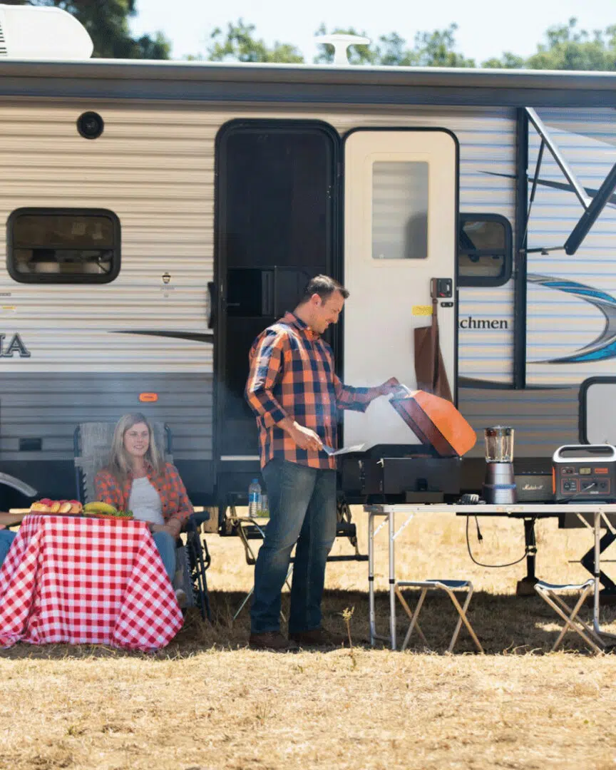 Guests outside their camper at a full-hookup site